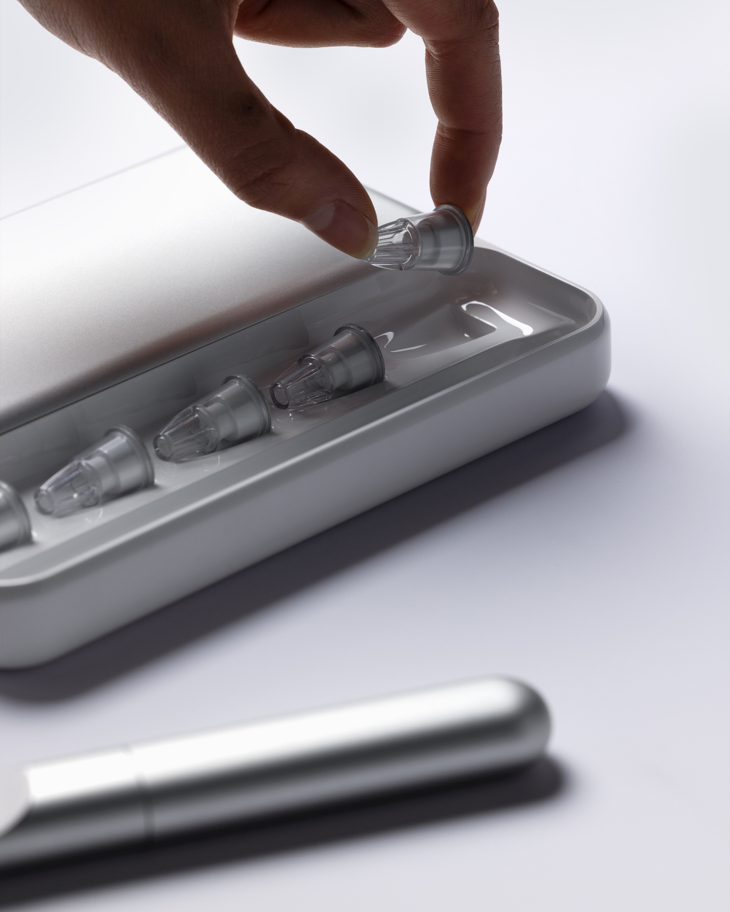 Hand lifting a replacement insulin cartridge out of a metallic storage case