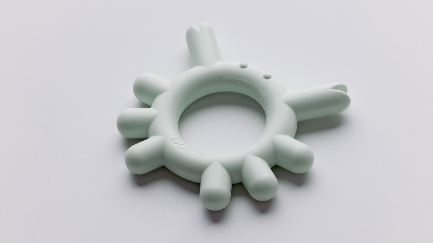 Green-coloured circular silicone teether ring shown on a light background.