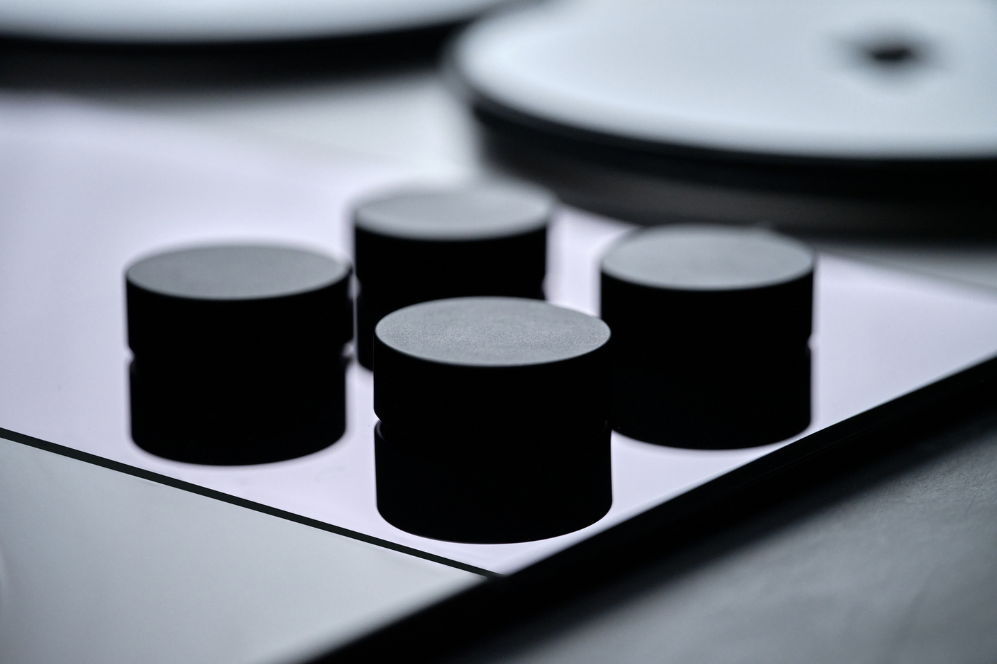 Detail view of four circular rotary control knobs on a stovetop panel