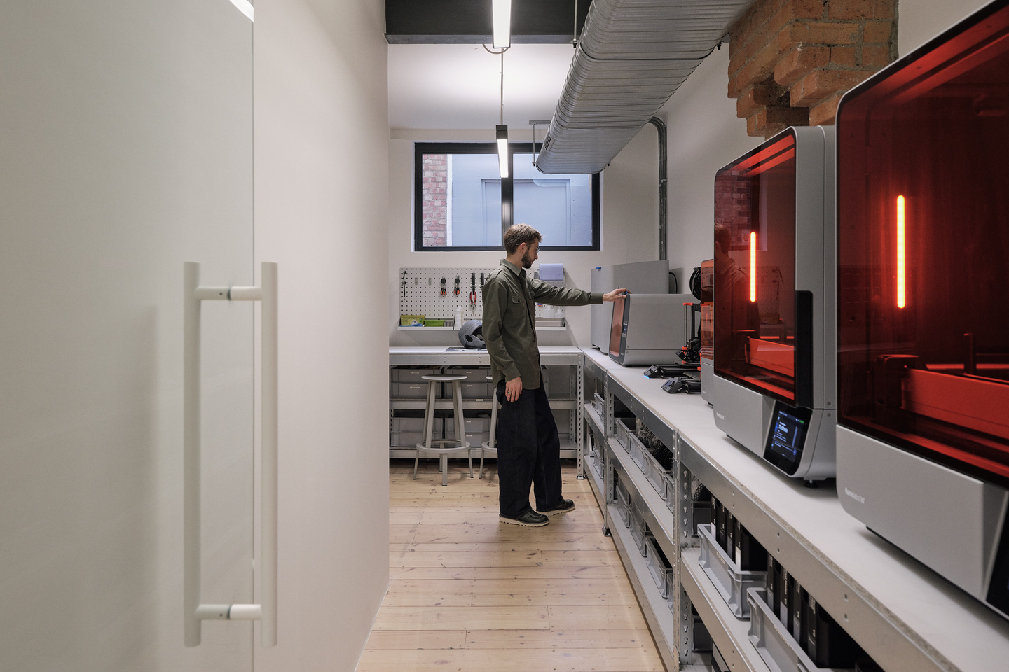A photograph of the BLOND workshop with a designer working on one of the printers
