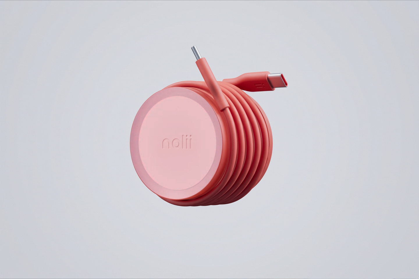 Red circular cable winder accessory resting on a light grey background