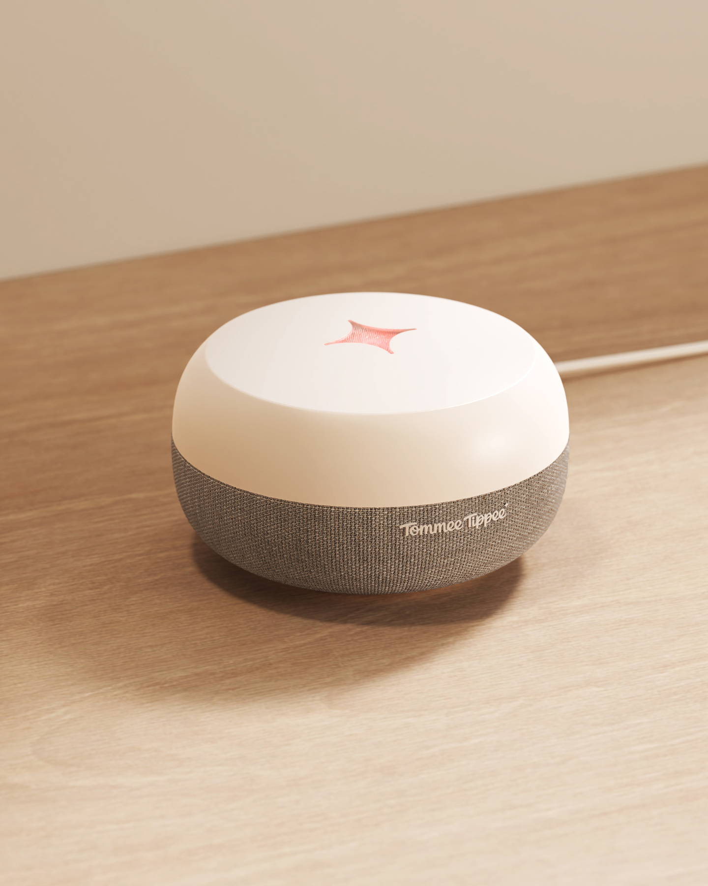 White and grey round device resting on a wooden desk