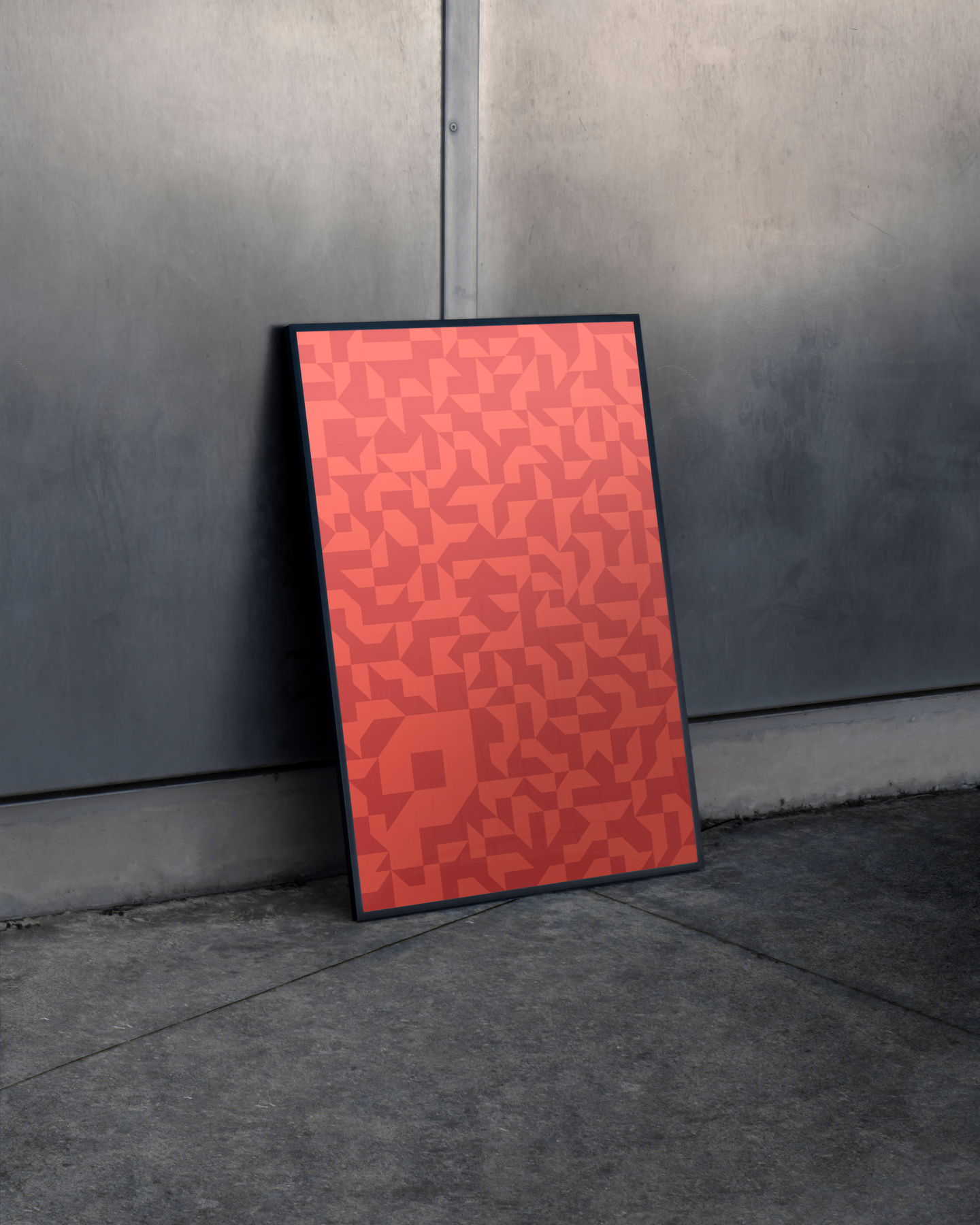 Red poster featuring repeating pattern resting inside a black frame against concrete.