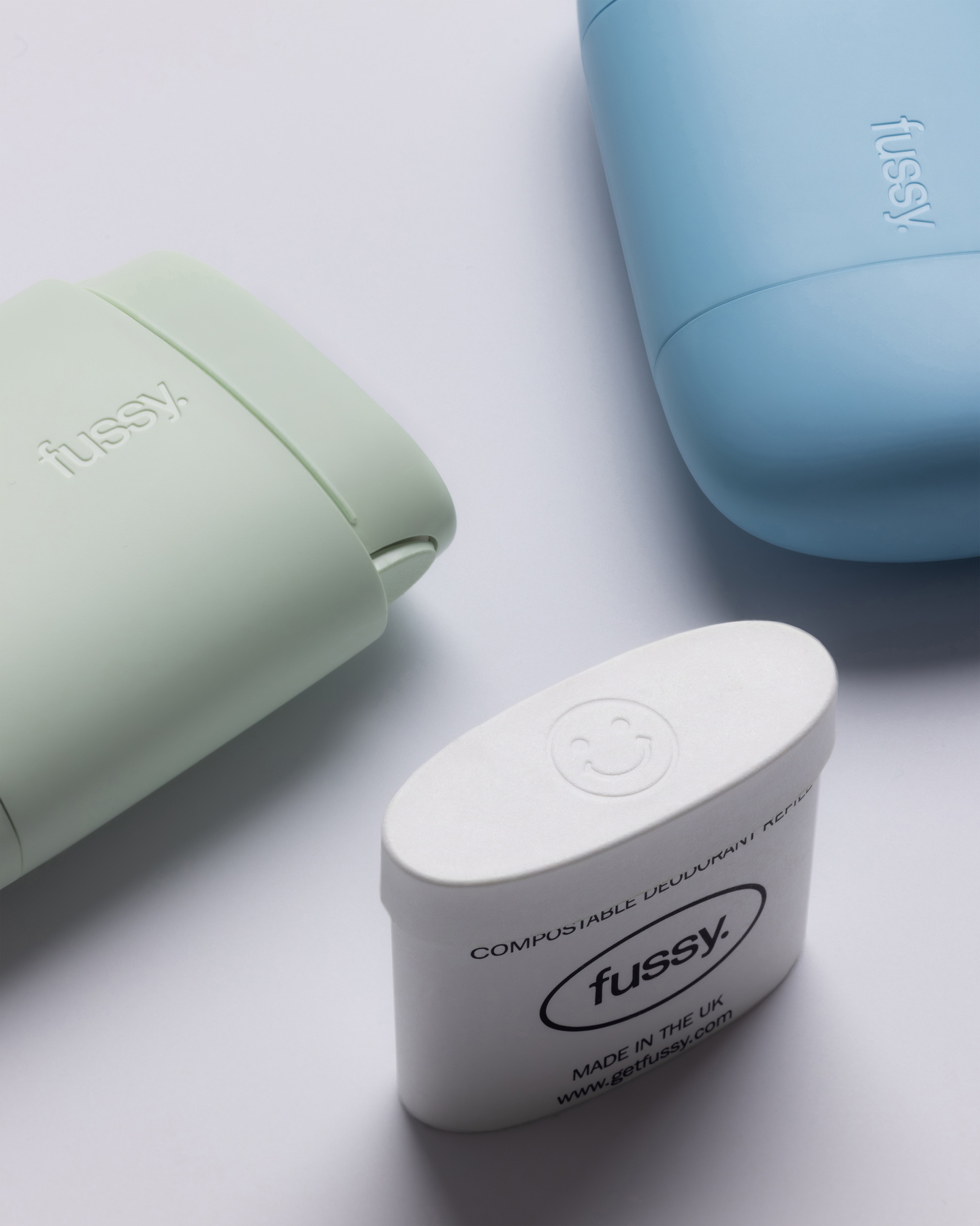 Mint green and light blue Fussy cases next to an uncovered white refill pod.