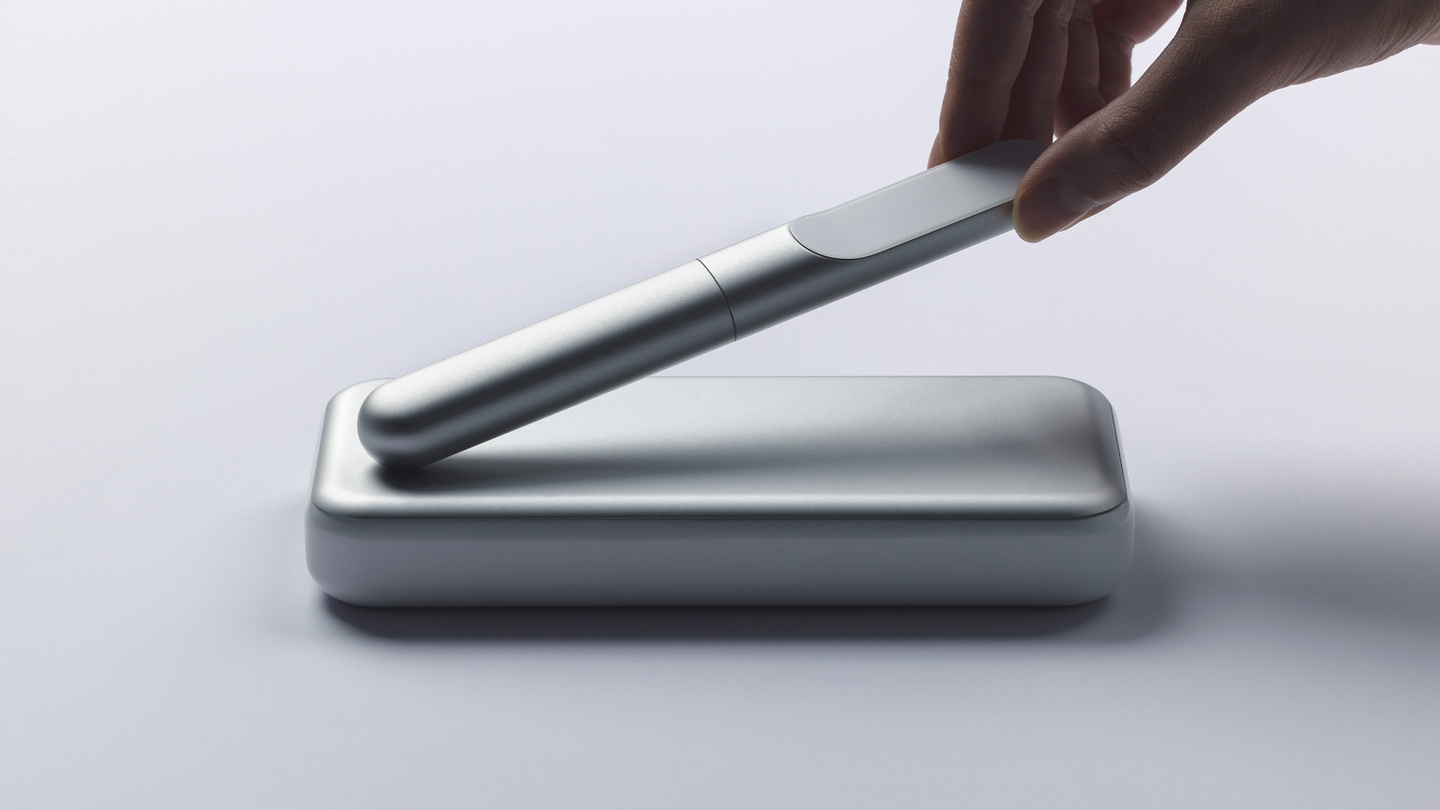 Hand placing a sleek metallic smart insulin pen into its open silver carrying case