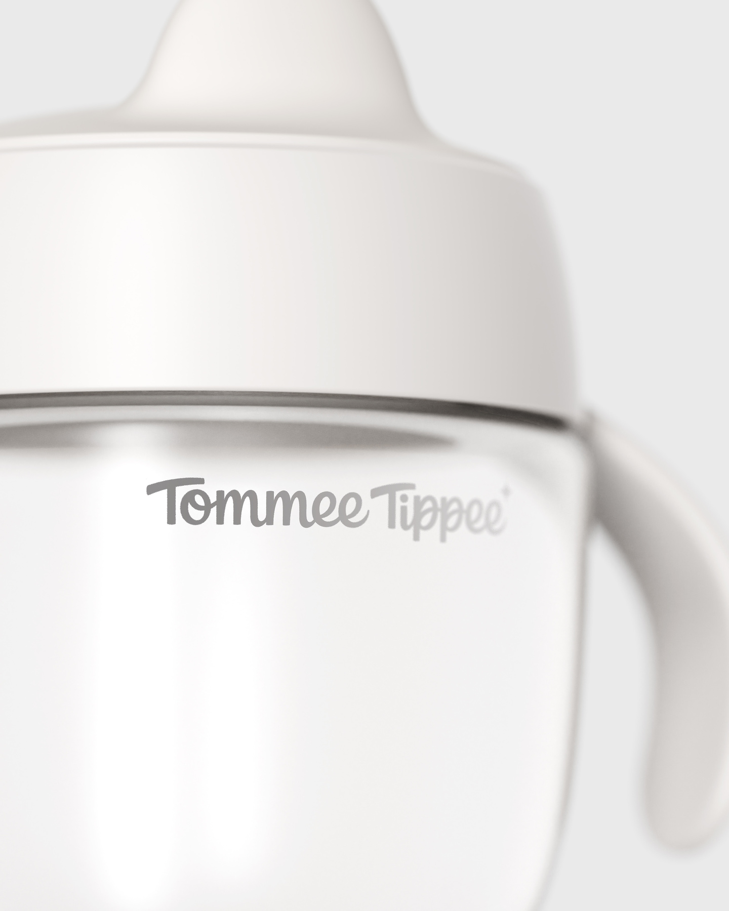 Close-up view of a white sippy cup with Tommee Tippee logo