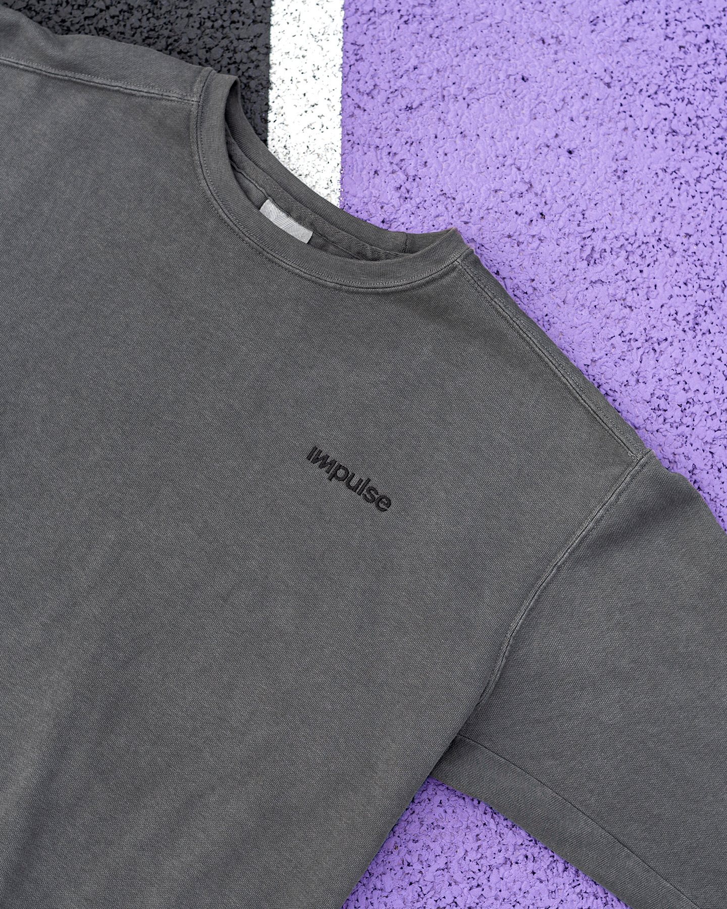Close-up of grey jacket fabric against a purple background