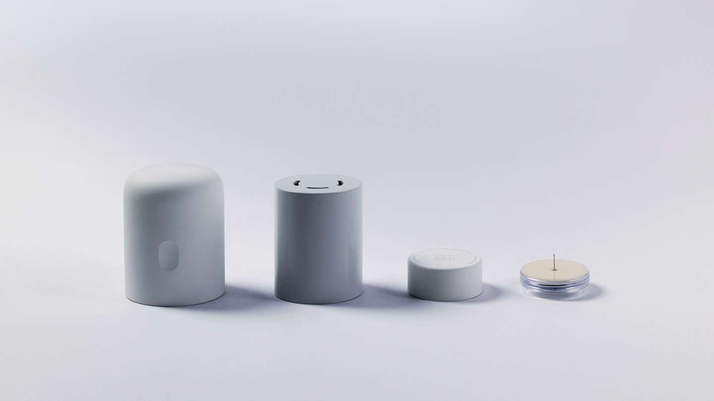 Lineup of four CGM system components showing the applicator body, inner mechanism, sensor, and needle disk
