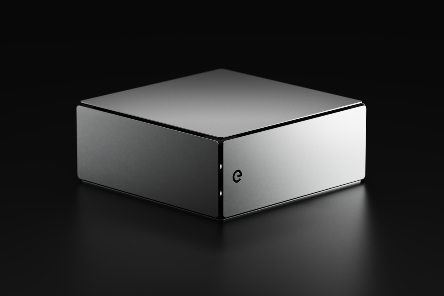 Studio render of rectangular grey electronic hardware device on plain dark surface
