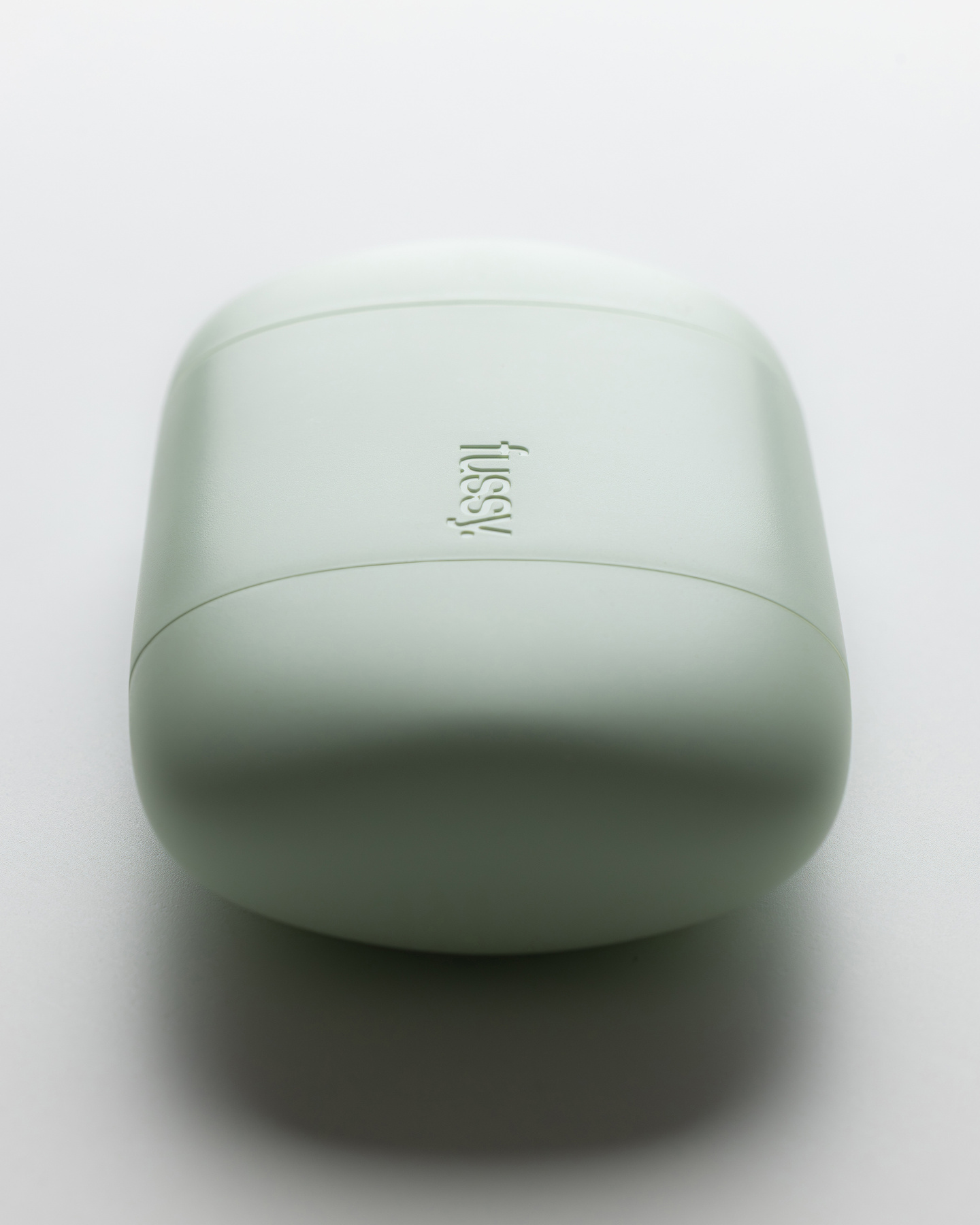 Top view of a closed mint green Fussy refillable deodorant case on a white surface.