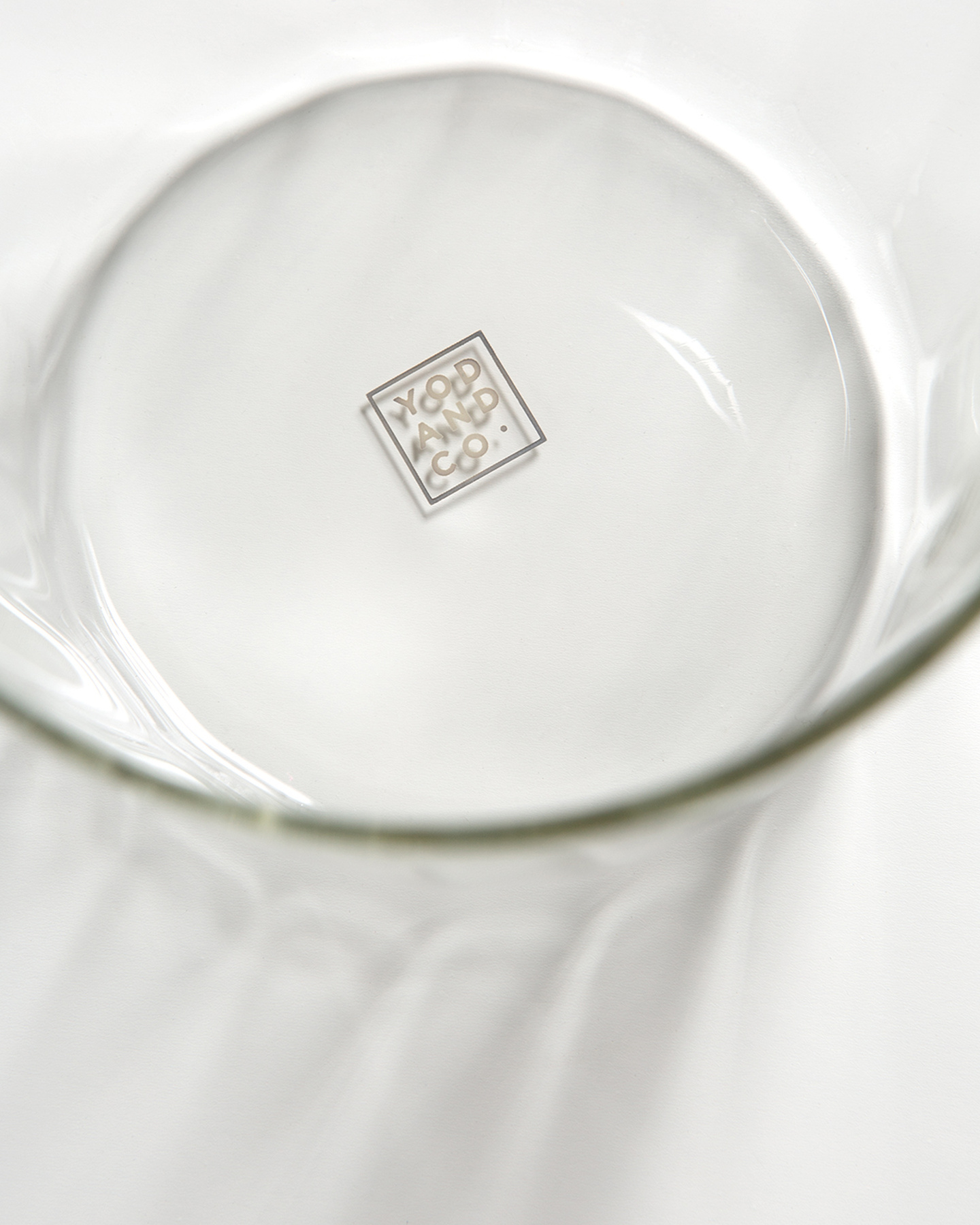 Circular base of a clear glass vessel showing brand marking