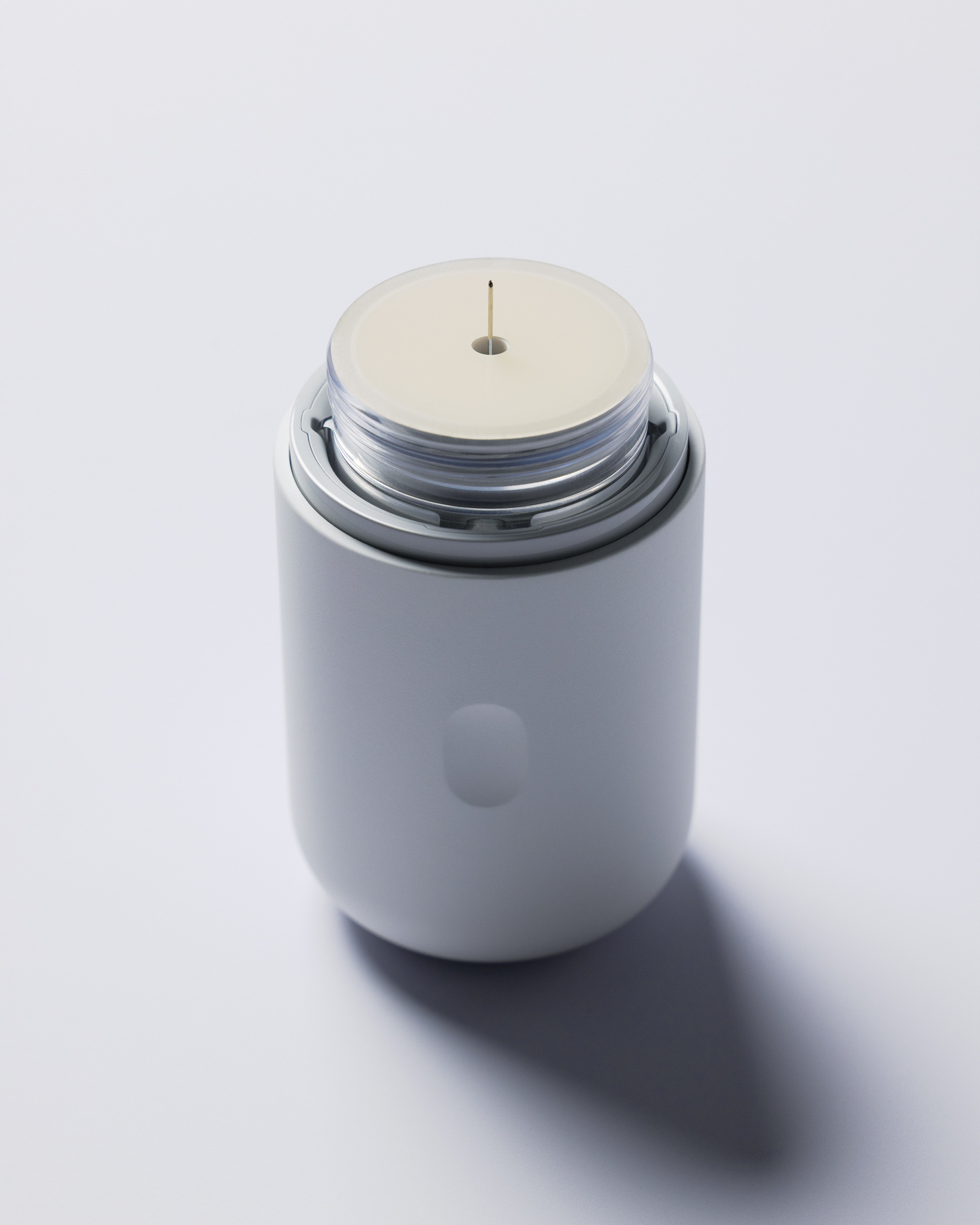 Top view of a white applicator showing the internal spring mechanism and insertion needle assembly