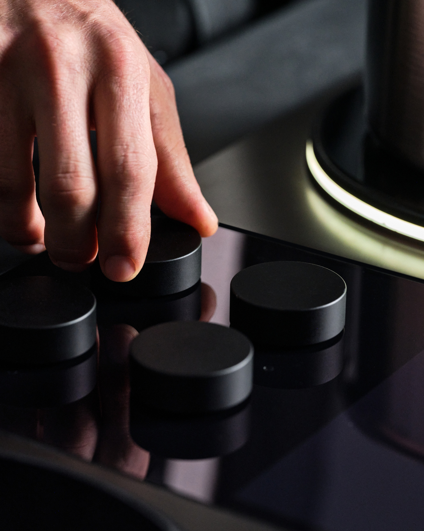 Close-up view of a hand turning a rotary control dial on a stovetop