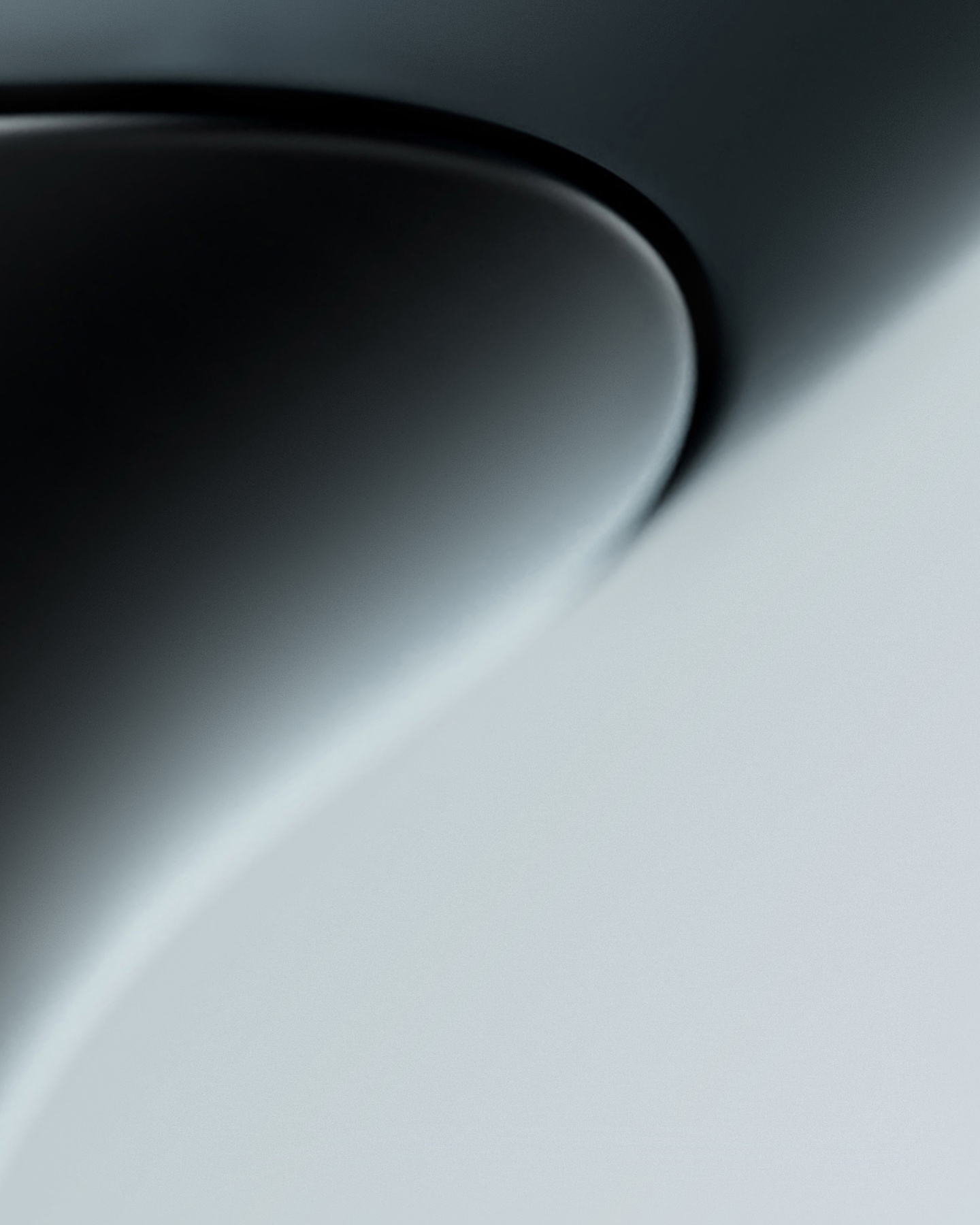 Close-up view of a smooth curved metallic surface with light and shadow gradients