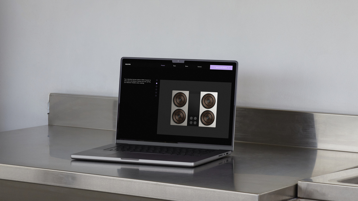 Laptop resting on a stainless steel counter showing website layout
