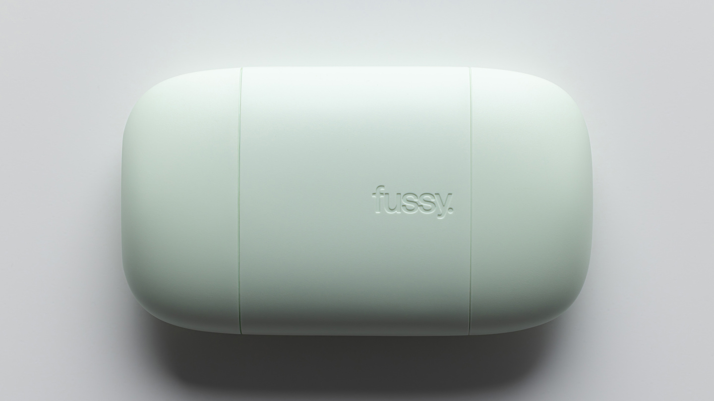 Top-down view of a mint green Fussy refillable deodorant case lying horizontally.