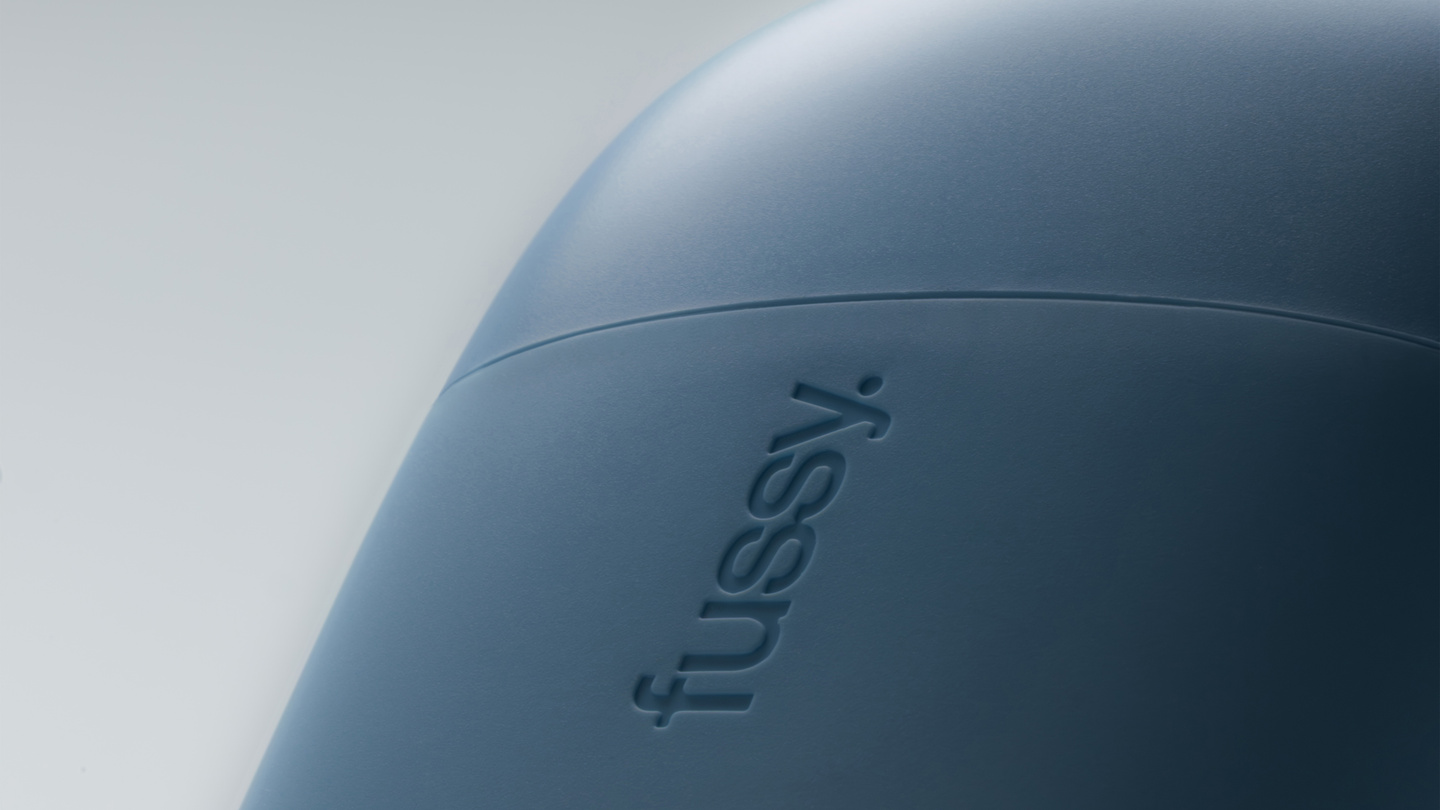 Detailed close-up of a dark blue case showing the debossed Fussy logo text.