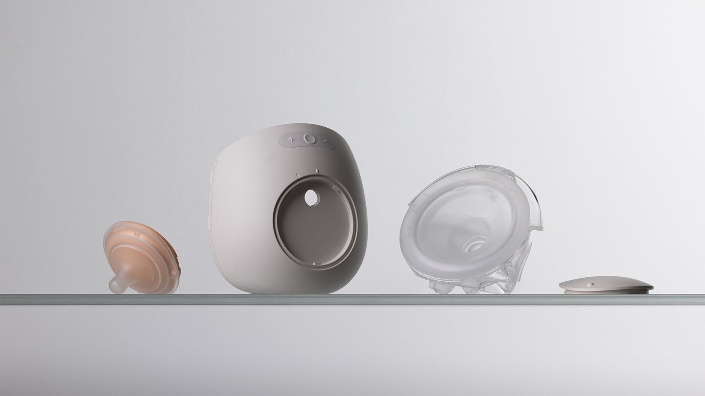Four disassembled components of the Avira breast pump arranged on a shelf.