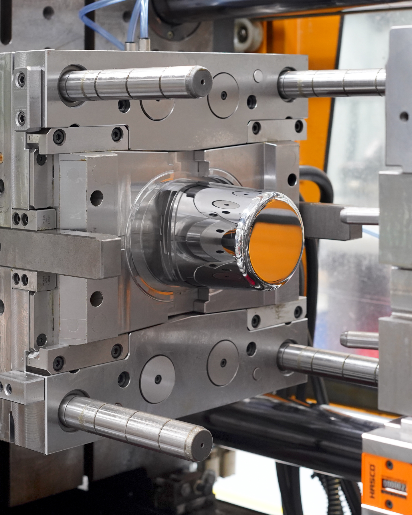 Close-up of injection moulding tool in factory setting.