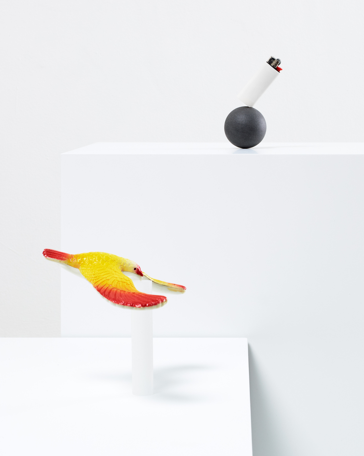 Brightly colored design prototypes displayed on white pedestals