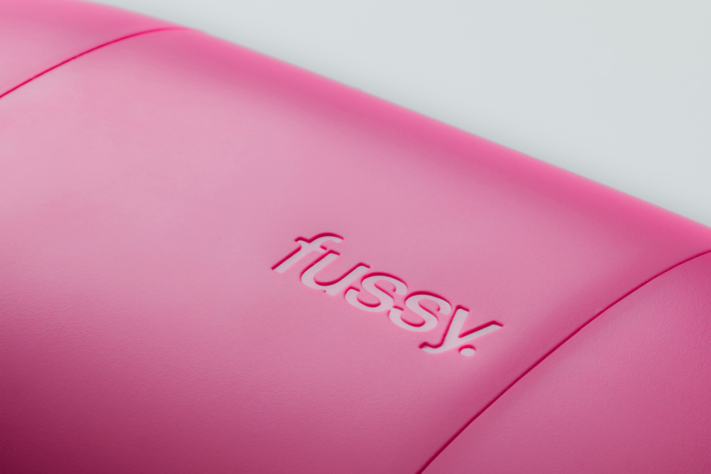 Close-up view of the smooth edge and seam of a bright pink Fussy deodorant case.