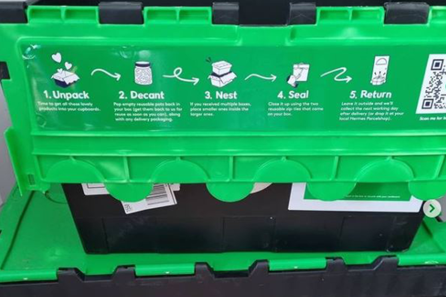 Bright green plastic transport crate fitted with a black secure lid section.